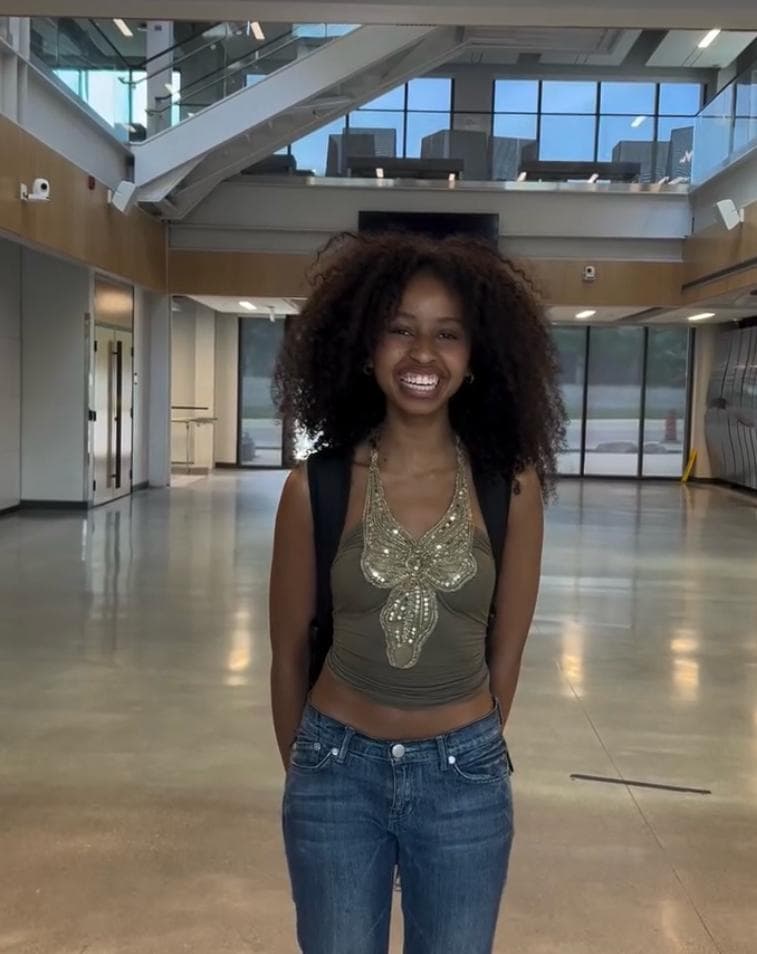 Student smiling in a bright campus atrium