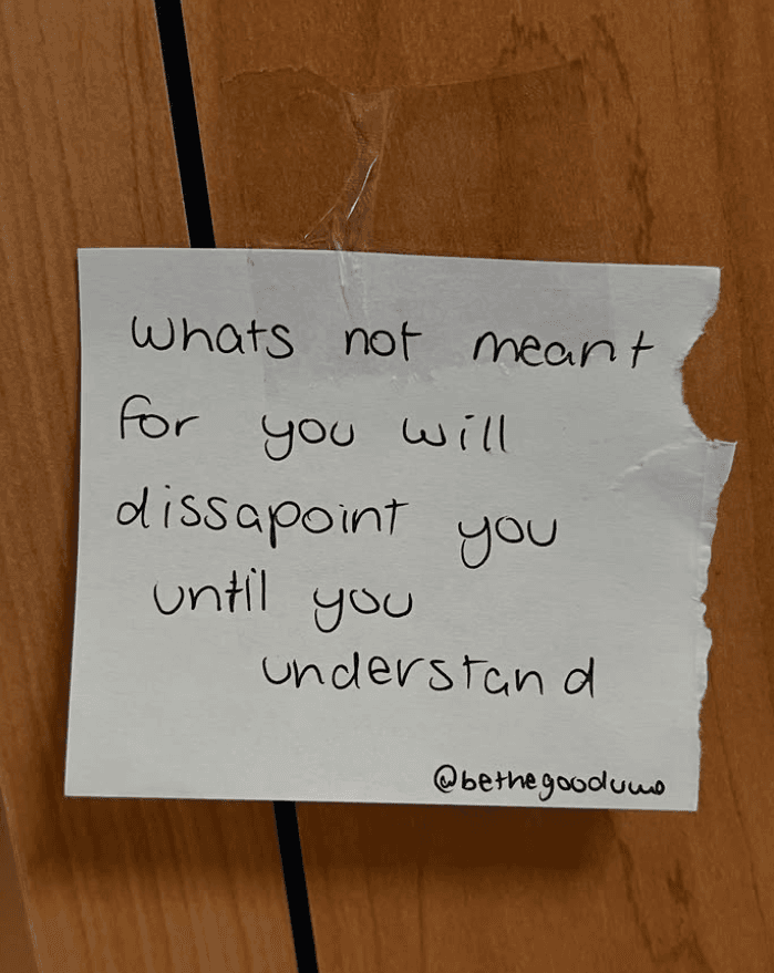 Handwritten kindness note taped to wood